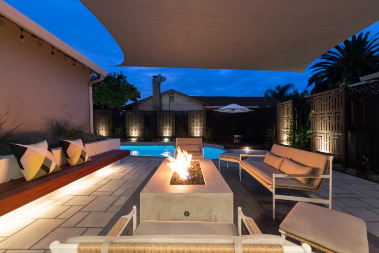 outdoor fireplace with pool and stone patio