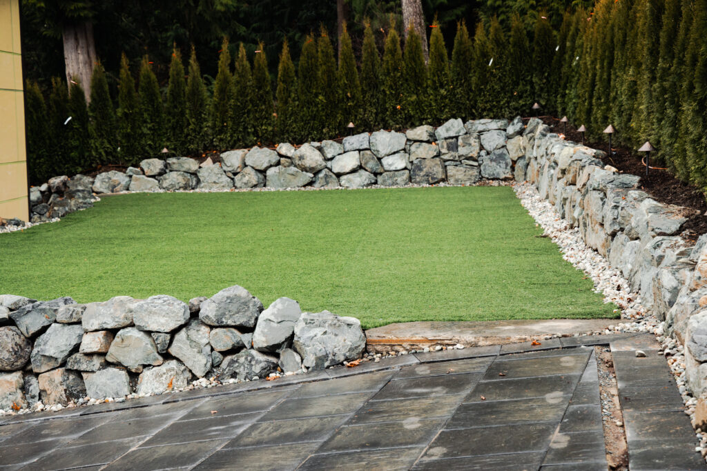 Synthetic grass backyard lawn in Everett with paver border